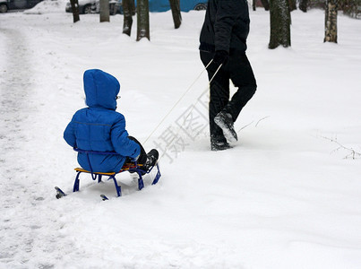 拖拽人们滑动坐在雪橇拖拉机上的儿童形象图片