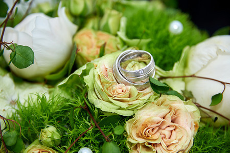 绽放带有玫瑰和戒指的婚礼花束春天银图片