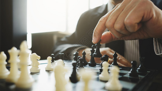 男人白色的商业在任战略和竞争概念中玩棋子的商人象游戏图片