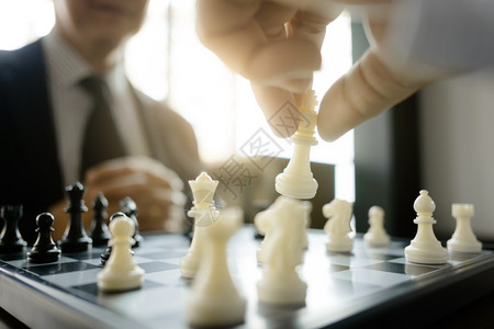 竞赛在任战略和竞争概念中玩棋子的商人象游戏脑桌子图片