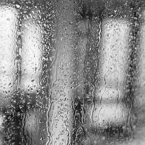 一种珠子清除在背景的窗口帘上雨滴图片