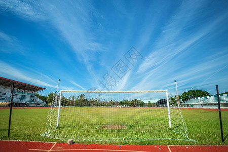 晴天地面在蓝背景的体育场上足球赛或门草皮图片
