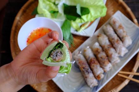深的自制经过吃春卷糕饼或烤焦饭是越南菜食中流行的物由肉和包装纸用米塞成然后深炸吃沙拉和鱼酱图片