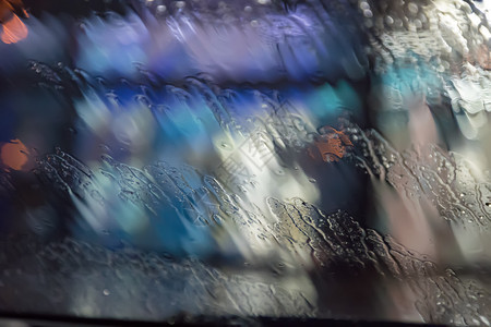 眼泪窗户上的雨滴玻璃水湿玻璃表面城市的灯光在雨中闪耀有质感的颜色图片