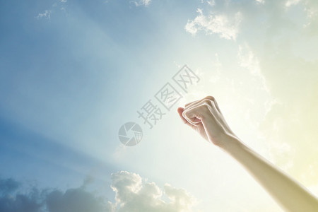 手在空气中长大的人拳头有着明亮的天空和阳光背景民主图片