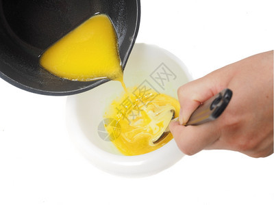 银手盘子人们在搅拌时将来自水壶的融化黄油添加到塑料碗中的混合体图片