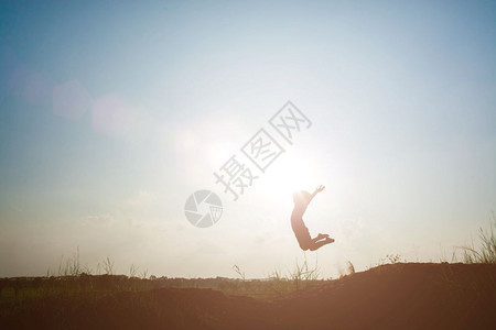 夏天日落小男孩跳上天空玩得开心Sillhouette概念剪影图片