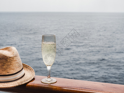 闲暇在蓝海浪背景下的游轮露天甲板上美丽的香槟杯侧观封闭式休闲和旅行概念在露天甲板上美丽的香槟杯面上美丽香槟酒杯清除填充图片