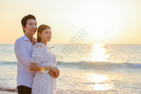 丈夫女朋友海洋年轻快乐的亚裔夫妇在海滩上拥抱浪漫旅行蜜月渡假暑亚洲女和男在日落背景下手抱着户外图片