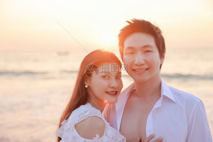 男朋友水爱年轻快乐的亚裔夫妇在海滩上拥抱浪漫旅行蜜月渡假暑亚洲女和男在日落背景下手抱着户外图片