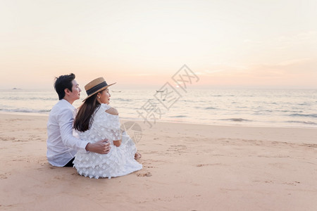 男人女孩夏天年轻快乐的亚裔夫妇在海滩上拥抱浪漫旅行蜜月渡假暑亚洲女和男在日落背景下手抱着户外图片