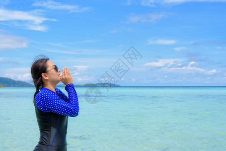 美丽的自然响亮身穿蓝泳装和太阳镜的亚洲女在夏天前往泰国KohLipe岛时使用扩音器手对海嘴大喊叫蓝色天空夏季背景与蓝天泰国夏日用图片