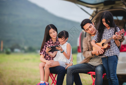妈快乐的小女孩与亚裔家庭一起玩乌鲁莱尔语坐在车里享受公路旅行和暑假人们游客图片