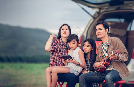 运输快乐的小女孩与亚裔家庭一起玩乌鲁莱尔语坐在车里享受公路旅行和暑假人们女儿图片
