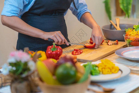烹饪生的切碎在现代厨房饮食和健康品概念下在购物板上剪切近身主厨的手切除胡椒图片