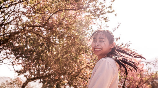 快乐的亚洲妇女在春天阳光明日公园里享受自然与的快乐花游客情绪化的图片