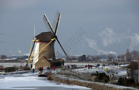玩农场身体人们在荷兰风车前溜冰图片