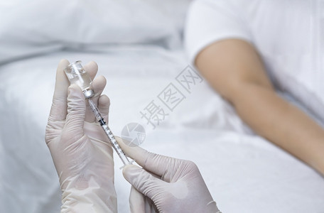在室内手套泰国专注在医生手握时将注射针筒用瓶子抽打到医院病房的床上以便注射给病人图片