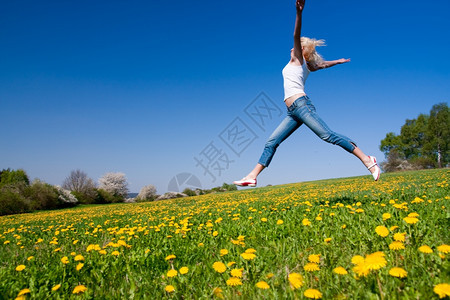 福利年轻女子在花朵茂盛的草原上玩得开心微笑天空图片