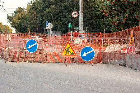 秋季城市街道建筑工地的市区街道路修理有障安全围栏网道路工程和绕行标志秋季城市街道上的封闭横行路施工秋季道程和绕行线作秋季市街道通图片