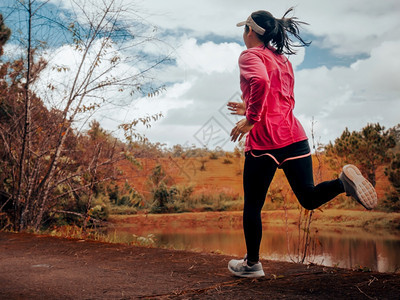 山在湖边的森林中奔跑运动妇女在早上锻炼运动中的自然者健康生活方式概念一健康生活方式概念早晨松弛图片