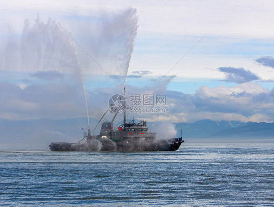 漂浮的海运输动拖船正在喷射水柱浮动拖船正在喷射水柱图片