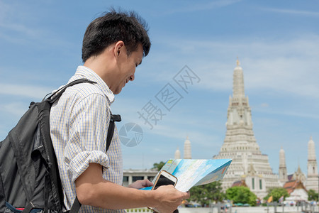 一种在泰国WatArun身穿格衬衫手持智能机及的男子人图片