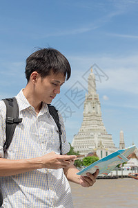 电话在泰国WatArun身穿格衬衫手持智能机及的男子假期抓住图片