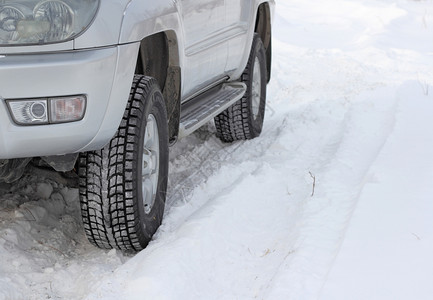 在一辆无法辨认的汽车前面雪冬路警告危险的天气图片