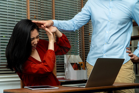 亚洲人一种老板试图触摸一名年轻女雇员在工作场所的肩部她感到不舒服害怕虐待和不适当的虐待工作场所骚扰概念工作单位骚扰概念接触图片