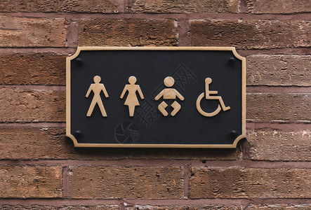 椅子在黑金和墙上挂着字母和框架的所有别卫生间标志WC公共卫生间标志上的厕所图砖墙上有一个男女儿童及残疾人符号绅士们图片