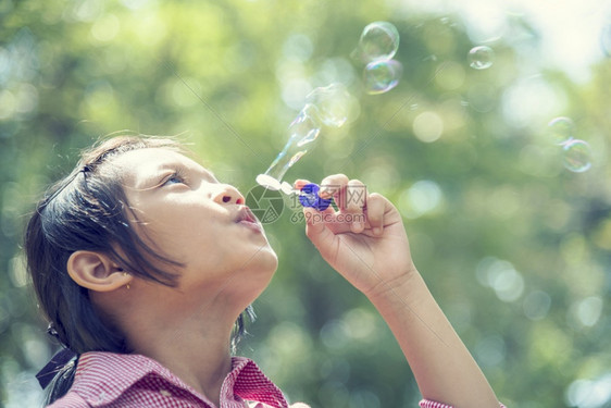 快乐可爱的女孩在夏季户外绿色游乐场玩耍泡沫在公园快乐时光中欢笑愉快的女孩在自然公园吹肥皂的泡闲暇乐趣快的图片