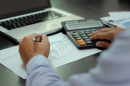 帐户商业金融税务和投资概念在书桌和计算器上手持笔和商务文件的人手掌成功花费图片