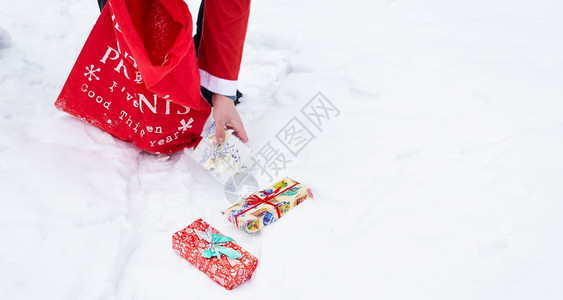 孩子们家庭装扮成圣诞老人的横幅在雪地里的林收集礼物装满的彩色盒子装着圣诞老人的横幅在雪地里的收集礼物装着的彩色盒子男人图片
