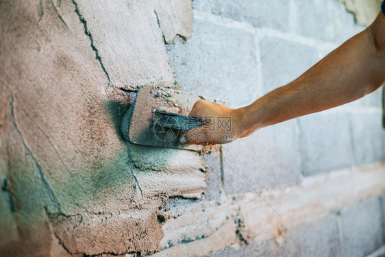 建筑学重新装修工人们在建筑房屋墙上涂水泥的紧手工匠图片