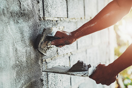 劳动质量工程人们在建筑房屋墙上涂水泥的紧手图片