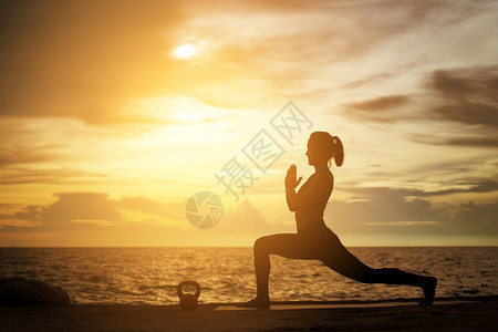 和平冷静的体式在超现实日落的海边健康概念和锻炼中在超现实日落期间从事瑜伽的妇女图片