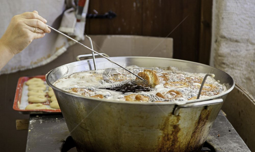 炒平底锅油炸糕饼自制甜点糖和圈中的油炸土豆甜圈图片