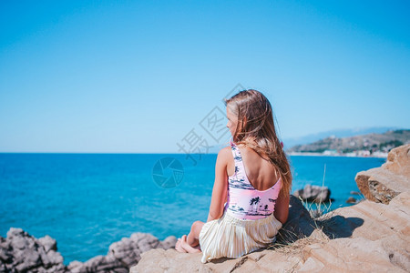 阳光请享用积极的悬崖海岸边缘可爱女孩享受山顶岩石风景在悬崖海岸边缘露天的小女孩图片