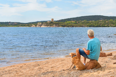 海景男人和他的狗在Bonifacio附近的Corsica南部和海岸的热那亚塔休息岛灰色的图片