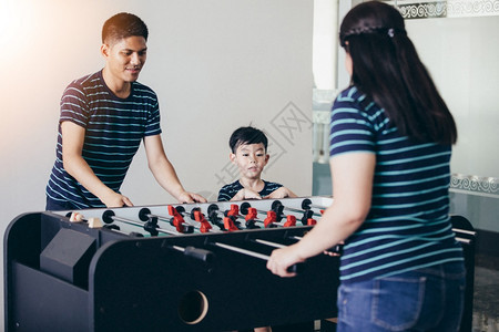 年轻的竞赛家庭快乐打桌球在家放假休息时松美丽的图片