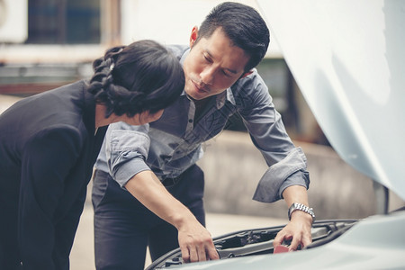 户外商人帮助女检查和修理破损的汽车成人运输图片