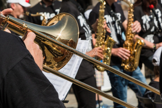 笔记金的乐器BrasTrombone外门音乐会时背景中的金萨克斯风图片