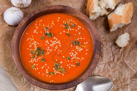 新芽开胃菜粉碎棕纸上木碗中的番茄汤玉米图片