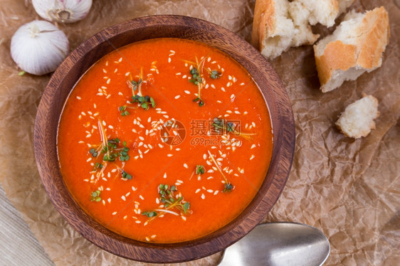 新芽开胃菜粉碎棕纸上木碗中的番茄汤玉米图片
