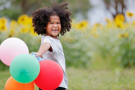 女儿金发玩具一个小卷女孩在户外玩气球图片