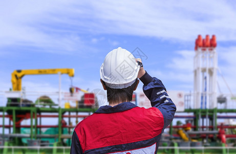 港口在造船厂从事油轮作业前身着白色安全头盔的蓝机械穿衬衣年轻工程师的后视镜运输连身衣图片