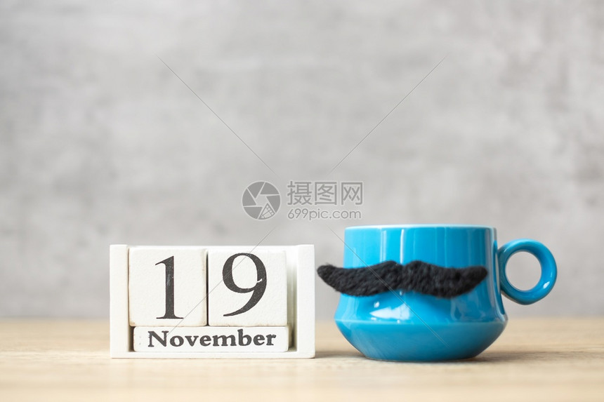 快乐的国际男子日1月9历蓝咖啡杯或茶和黑胡子装饰品在桌边快乐父亲节和庆祝概念帕努瓦典图片