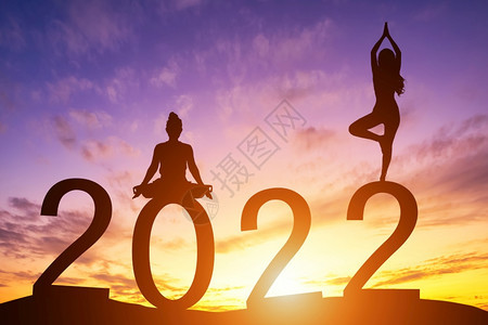 庆祝早晨晚上新年快乐20席丽休埃特女在清晨做瑜伽地平线背景健康与新年概念上日出图片