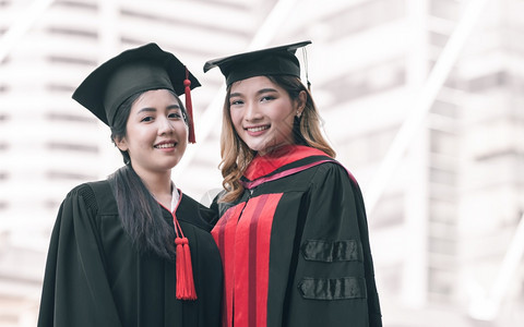 两位身穿学士服拍照的微笑女孩图片